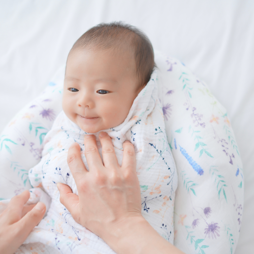 おくるみタッチケアで布に包まれた赤ちゃんに優しく触れている様子