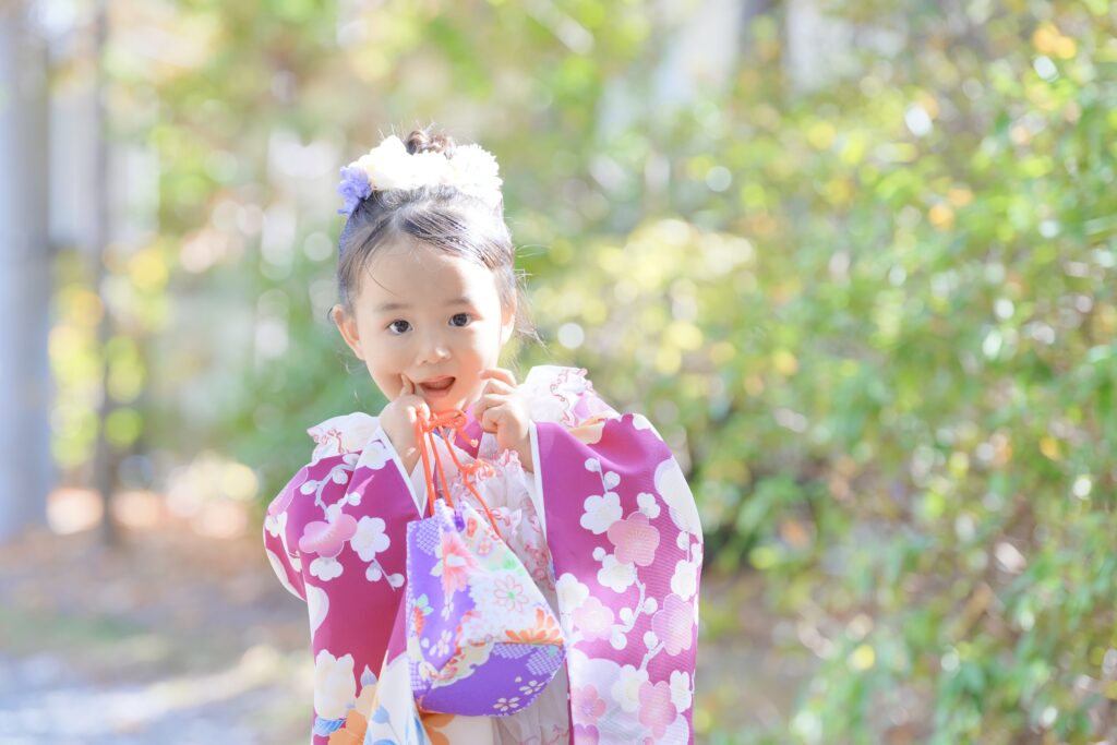 七五三フォト撮影でピンクの晴れ着を着た女の子が笑顔を見せている様子