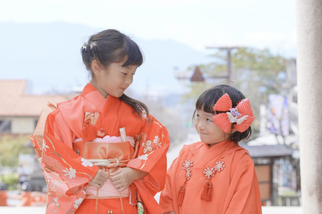 ロケーションフォト撮影で晴れ着を着た姉妹が見つめ合っている様子