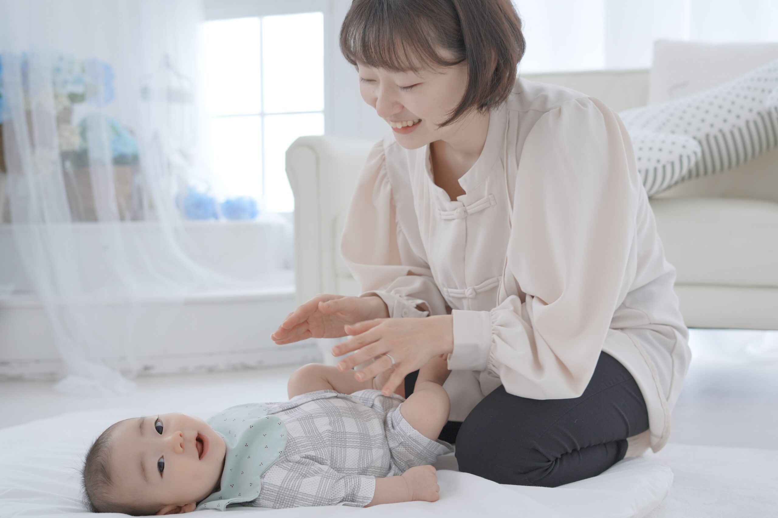 ベビーマッサージとフォト撮影でママが赤ちゃんに優しく触れている様子