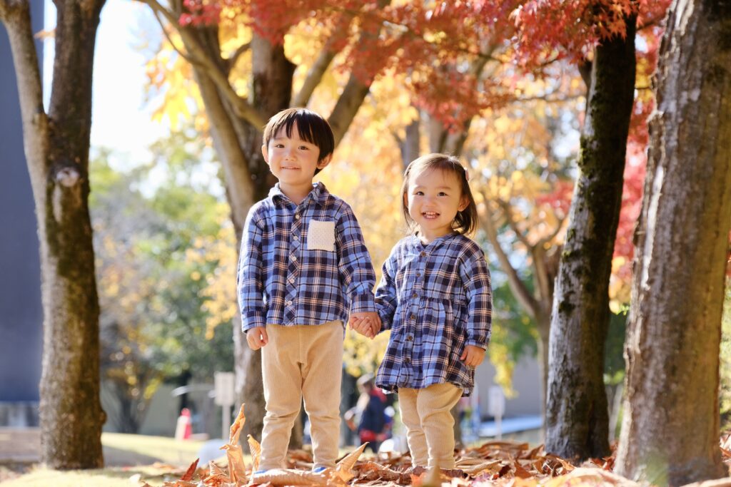 秋の紅葉ロケーションフォト撮影で手をつないで立つ兄妹の様子
