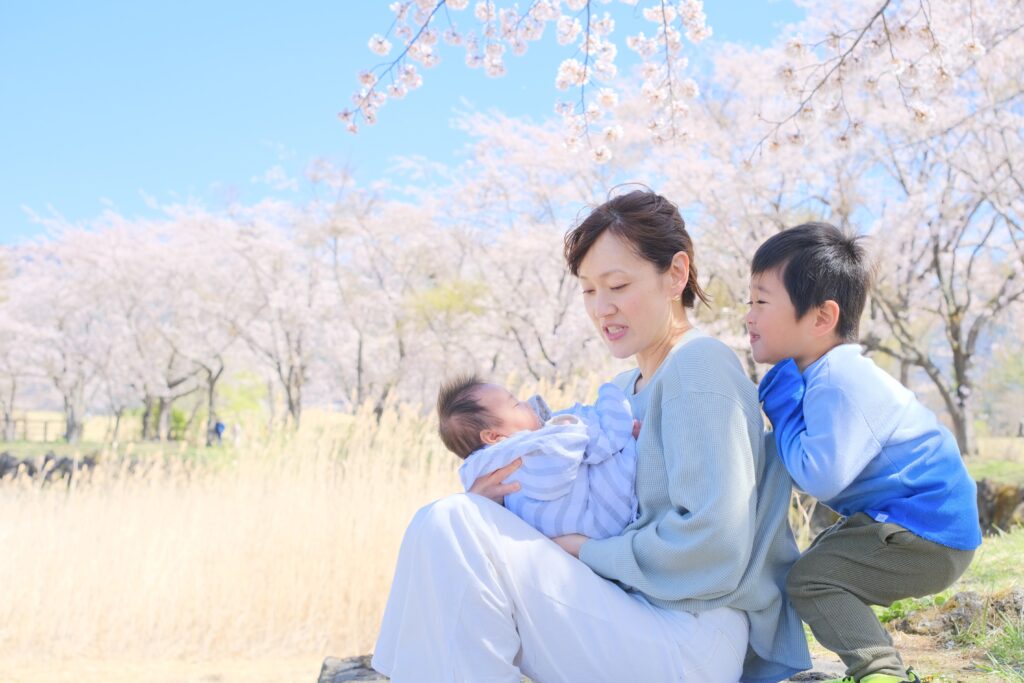 桜のフォト撮影で赤ちゃんを抱くママと兄弟が過ごしている様子